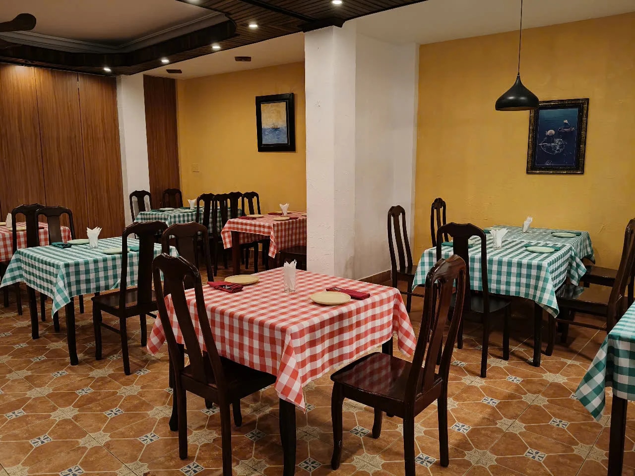 The restaurant features a cozy indoor dining space with elegant lighting and tasteful decor